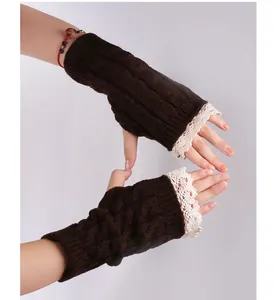 Détail des mitaines en tricot torsadé marron avec une bordure en dentelle élégante.
