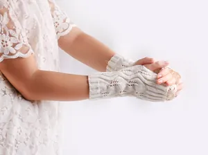 Detail view of cream crochet knitted fingerless gloves with elegant lace trim for winter