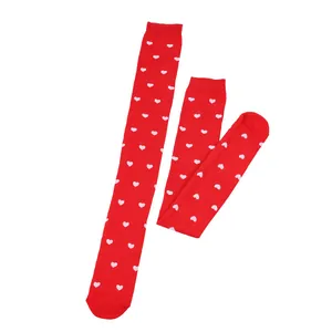 Detail view of red thigh high socks with pink heart pattern for Valentine's Day party