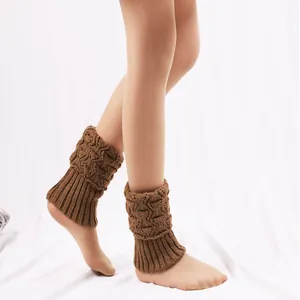 Macro view of brown knitted short leg warmers featuring a stylish hollowed texture and ribbed trim