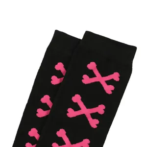 Detalle de calcetines altos negros con estampado de huesos rosas para fiestas de Halloween