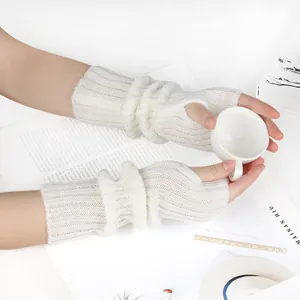 Close-up of white knitted fingerless arm warmers with a soft ribbed texture detail.