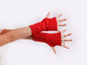 Detailed view of red knit fingerless gloves with white lace trim and cable pattern