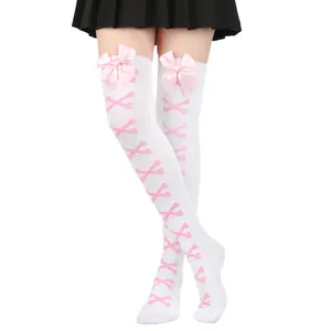 Détail de chaussettes montantes blanches avec de jolis nœuds roses et motif d'os
