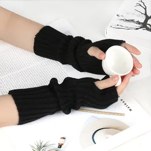 Close-up of black ribbed knitted fingerless arm warmers worn while holding a cup