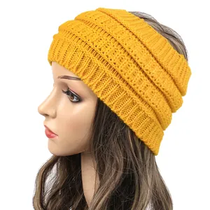 Detailed side view of a mustard yellow wide knitted winter headband for women on a mannequin