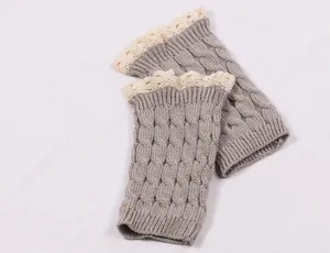 Close-up view of grey cable-knit leg warmers featuring elegant cream lace trim detail.