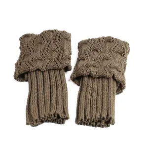 Close-up of brown knitted boot cuffs with hollow pattern and scalloped fold-over edges