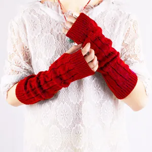 Detailed view of red cable-knit fingerless arm warmers paired with a white lace top