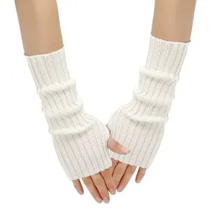 Close-up of white knitted fingerless gloves featuring a thumb hole and ribbed texture.