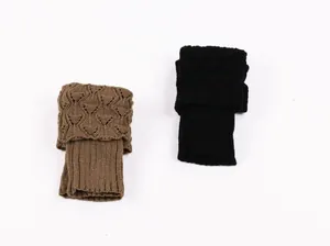 Close-up of short knit leg warmers featuring hollow-out crochet patterns in brown and black