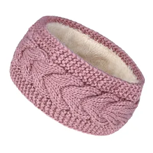 Detalle de una diadema de punto trenzado rosa con forro polar cálido en color crema