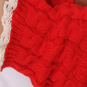 Macro detail of red cable-knit leg warmer featuring delicate white lace trim edge.