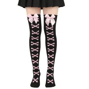 Vue détaillée des chaussettes hautes noires avec imprimé os roses et nœuds en satin