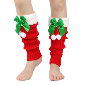 Close-up of red Christmas knitted leg warmers with green satin bows and white poms