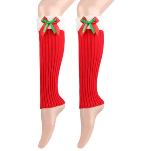 Detail of red knitted Christmas leg warmers with white plush trim and ribbon bows
