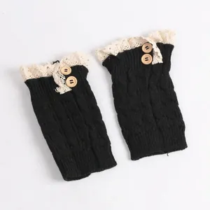 Detail view of black cable-knit boot cuffs with cream lace and wooden buttons