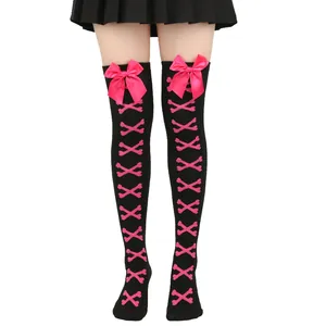 Détail de chaussettes hautes noires avec nœuds roses et motif d'os pour cosplay Lolita.