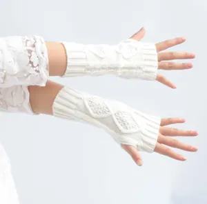 Close-up of white cable knit fingerless gloves showing warm textured arm warmers