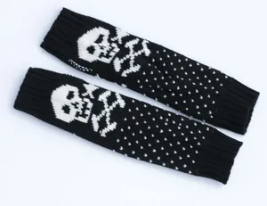 Close-up of knitted fingerless arm warmers with white skull and crossbones motif