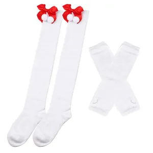 Detailansicht der weißen Overknee-Socken, verziert mit roten Schleifen und weißen Plüsch-Pompons