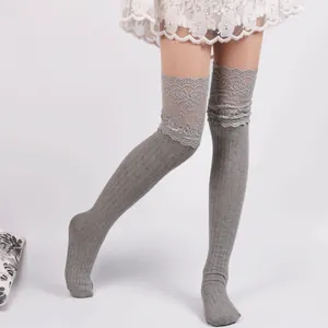 Detailed view of grey over-the-knee socks with lace trim and ribbed knit pattern