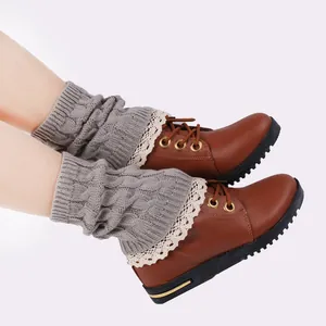 Cable knit leg warmers with delicate lace trim worn over brown boots.
