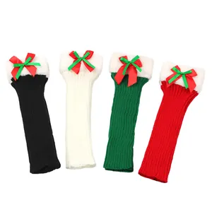 Close-up of four colors of Christmas knitted leg warmers with bows and plush trim.