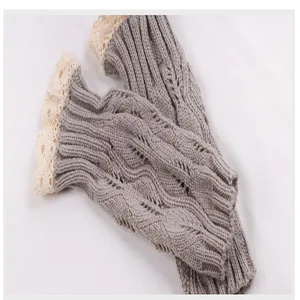 Close-up of grey knitted fingerless gloves with elegant beige lace trim detail