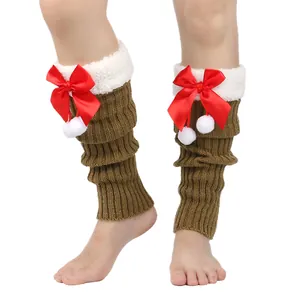Detailed view of brown knitted leg warmers with red bows and white fuzzy trim.