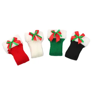 Detailed view of four pairs of knitted Christmas leg warmers with plush lining and bows