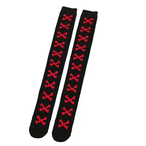 Detail view of black over-the-knee Halloween socks with red cross-bone patterns