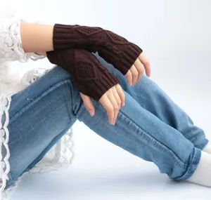 Detail shot showing the intricate cable knit pattern of brown fingerless gloves