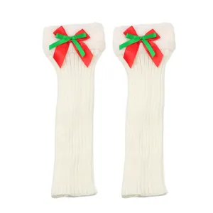 Cozy white knitted Christmas leg warmers featuring plush faux fur and festive ribbon bows