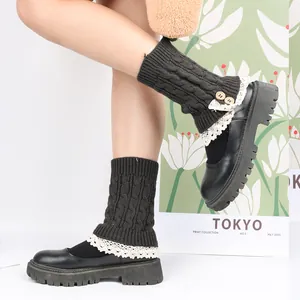 Close-up detail of knitted leg warmers featuring elegant lace trim and wooden buttons