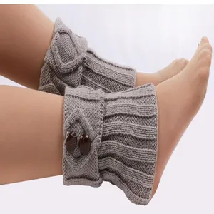 Nahaufnahme von gestrickten Beinstulpen mit dekorativen Knöpfen und Rippenstruktur