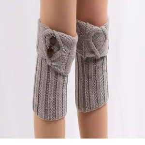 Detailaufnahme grauer Strickstulpen mit Vintage-Knöpfen und umgeschlagenem Bund