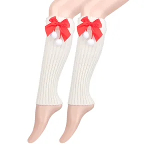 White ribbed knit leg warmers decorated with red satin bows and plush white pompoms.