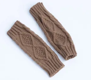 Close-up of brown knitted arm warmers with diamond cable knit pattern and ribbed cuffs