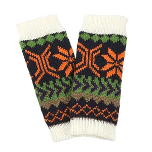 Detailed view of knitted fingerless arm warmers with orange snowflake patterns
