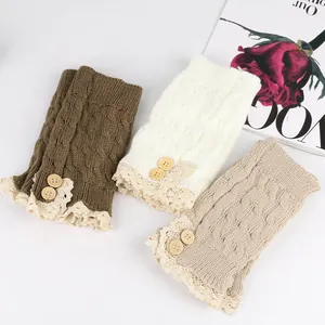 Close-up of knitted boot cuffs featuring lace trim and decorative wooden buttons
