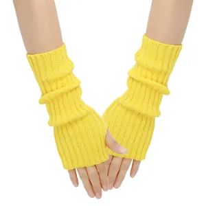 Close-up of yellow knitted fingerless gloves with ribbed texture and thumb hole