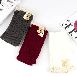 Detailed view of three pairs cable knit boot cuffs featuring lace trim and wooden buttons