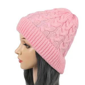 Side view of pink cable knit beanie hat showing warm knit texture and a ribbed folded cuff.