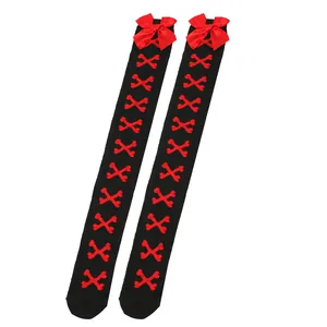 Vue détaillée de bas noirs au-dessus du genou avec des nœuds rouges et un motif d'os