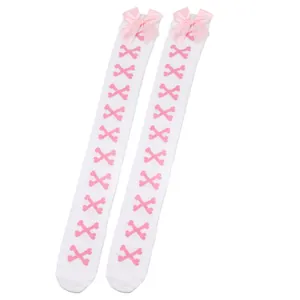 Détail nœud rose et motif os sur chaussettes hautes Lolita blanches au-dessus du genou