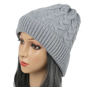 Close-up detail of a gray cable-knit beanie showing the warm knitted texture on mannequin