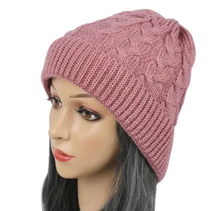 Detailed macro view of a pink cable-knit beanie worn by a mannequin on white background