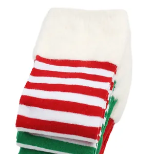 Detalle de calcetines navideños de 70 cm por encima de la rodilla con rayas rojas y puño de felpa.