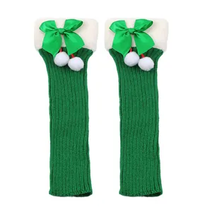 Festive green knitted Christmas leg warmers with white plush cuffs and satin bows